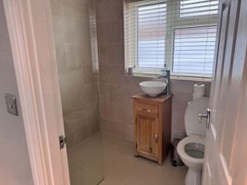A bathroom with a shower, toilet, sink, and cabinet at 15 Lamsey Lane, King's Lynn