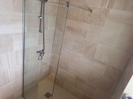 A shower with glass panel and wall tiles at 15 Lamsey Lane in King's Lynn