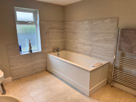 A bathroom with a bathtub and towel radiator at 15 Lamsey Lane in King's Lynn
