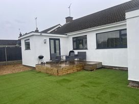 A garden with a deck and outdoor furniture at 15 Lamsey Lane in King's Lynn