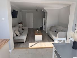 A living room with sofas and a table at 22 Sandringham Drive in King's Lynn
