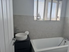 A bathroom with a bathtub and sink at 22 Sandringham Drive in King's Lynn