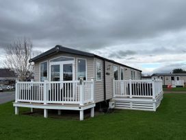 A mobile home with decking and glass doors at 55 Cambrian Park