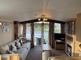 A living room with a sofa, coffee table, and television at 55 Cambrian Park