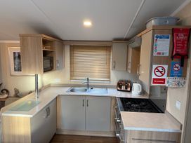 A kitchen with a sink, gas stove, and appliances at 55 Cambrian Park