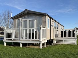 A mobile home with a deck and railing at Hafan Y Mor Haven Pwllheli