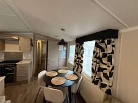 A kitchen with a dining table and chairs at Hafan Y Mor Haven Pwllheli