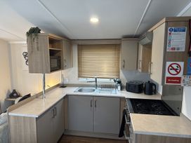 A kitchen with cabinets and appliances at Hafan Y Mor Haven in Pwllheli
