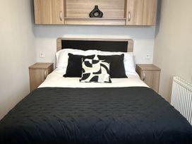 A bedroom with a bed and bedside tables at Hafan Y Mor Haven Pwllheli