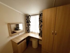 A bedroom with a desk and wardrobe at Hafan Y Mor Haven Pwllheli