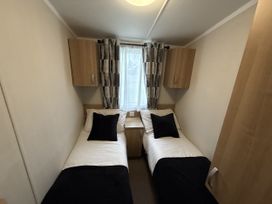 A bedroom with twin beds and wall cabinets at Hafan Y Mor Haven in Pwllheli