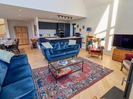 A living room with a sofa, coffee table, and television at 1 Dairy Fields Longframlington