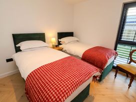 A bedroom with twin beds and a nightstand at 1 Dairy Fields Longframlington