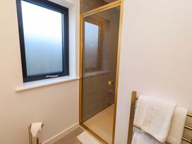 A bathroom with a shower and a towel rail at 1 Dairy Fields Longframlington