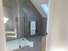 A bathroom with a shower and towel rail at The Barn in Longframlington