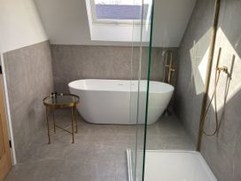 A bathroom with bathtub and shower at The Barn in Longframlington