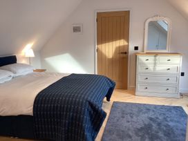 A bedroom with a bed and dresser at The Barn in Longframlington