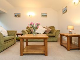A living room with a sofa and a table at Little Tregarrick in Helston