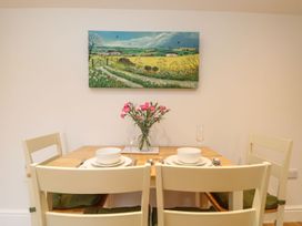 A dining room with a wooden table set for two at Little Tregarrick in Helston