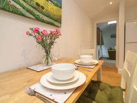 A dining room with a table set for meals at Little Tregarrick in Helston