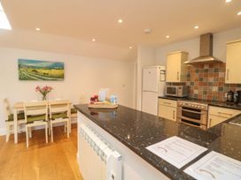 A kitchen with appliances and dining area at Little Tregarrick in Helston