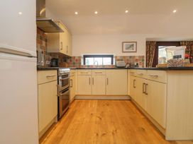 A kitchen with cabinets and appliances at Little Tregarrick in Helston