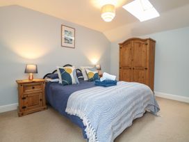 A bedroom with a bed and wardrobe at Little Tregarrick Helston