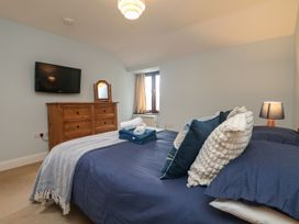 A bedroom with a bed and a dresser at Little Tregarrick in Helston