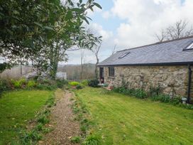 A garden with a gravel path and seating area at Little Tregarrick in Helston