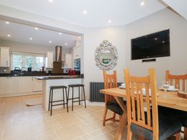 A kitchen with a dining area and appliances at Woodlands house in Ringwood