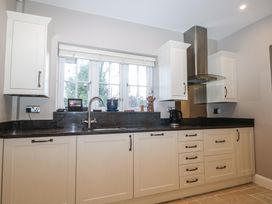 A kitchen with cabinets and sink at Woodlands house in Ringwood