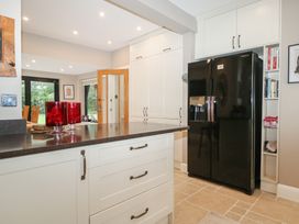 A kitchen with a refrigerator and cabinets at Woodlands house in Ringwood