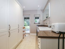 A utility room with cupboards and a sink at Woodlands house in Ringwood
