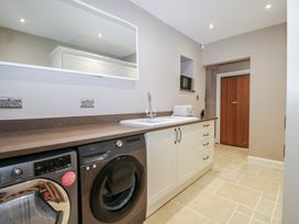 A laundry room with a washing machine and sink at Woodlands house Ringwood