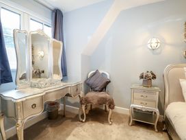 A bedroom with a vanity table and a chair at Woodlands house Ringwood