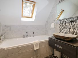 A bathroom with a bathtub and sink at Woodlands house in Ringwood