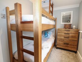 A bedroom with a bunk bed and a dresser at Woodlands house Ringwood