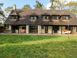 An outdoor area with a house and a hot tub at Woodlands house in Ringwood