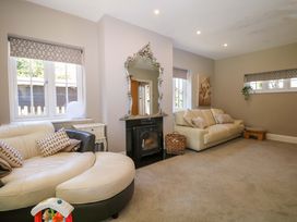 A living room with a sofa and fireplace at Woodlands House in Ringwood