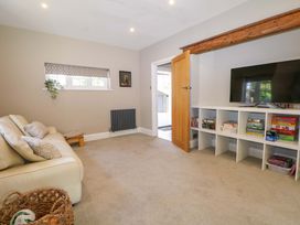 A living room with a sofa and television at Woodlands House in Ringwood