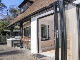 An outdoor area with a hot tub and bar stools at Woodlands House in Ringwood
