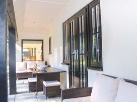 An outdoor porch with seating and a table at Woodlands House in Ringwood