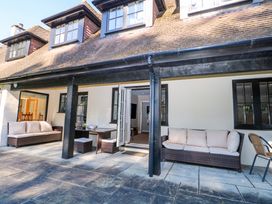 An outdoor patio with seating and a table at Woodlands House Ringwood