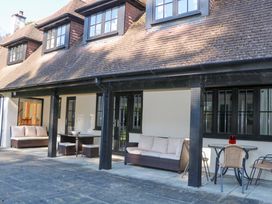 A patio area with outdoor seating and a table at Woodlands House in Ringwood