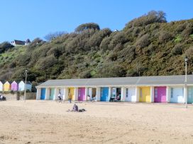 A row of beach huts and people at the beach at Woodlands House Ringwood