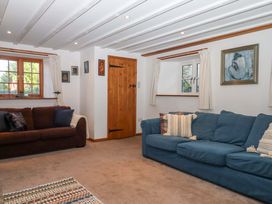 A living room with sofas and a wooden door at Park Cottage in Kingsbridge