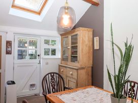 A dining room with a wooden cabinet and a table at Park Cottage in Kingsbridge