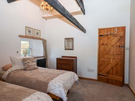 A bedroom with two beds and a chest of drawers at Park Cottage in Kingsbridge