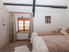 A bedroom with two beds and a window at Park Cottage in Kingsbridge