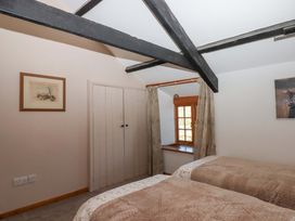 A bedroom with twin beds and a wardrobe at Park Cottage in Kingsbridge